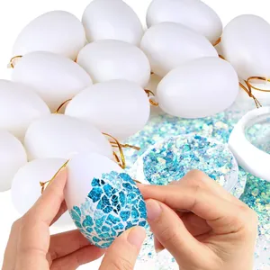 Close-up of hands decorating a white plastic Easter egg with blue glitter shards.