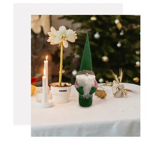 Detail of a green faceless Christmas gnome wine bottle cover in a festive holiday setting
