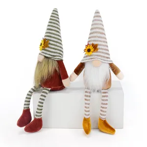 Close-up detail of two harvest festival gnomes with striped hats and long dangling legs