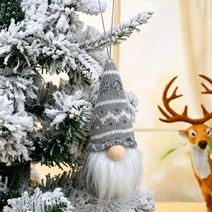 Detail view of a knitted grey and white Christmas gnome ornament hanging on a tree