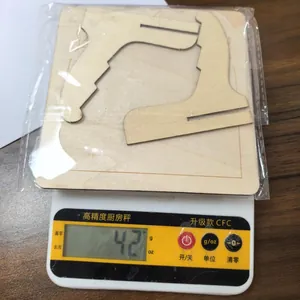 Close-up of a wooden DIY craft ornament kit being weighed on a digital scale, showing 42 grams