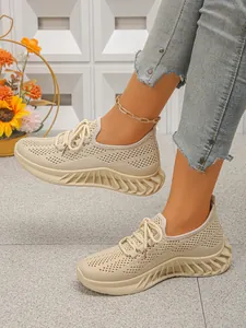 Détail montrant la texture tricotée respirante et la semelle ondulée des chaussures de sport.