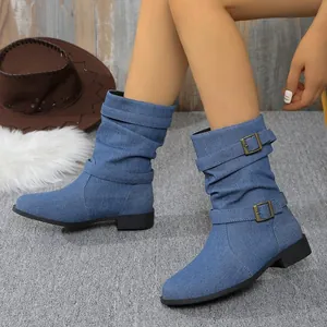 Detailansicht von Denim-Stiefeln mit Schnallenriemen im modischen Western-Stil.