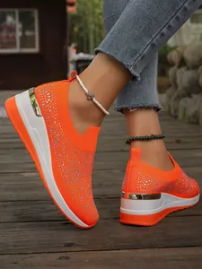 Vista dettagliata di sneakers con plateau arancioni con strass su tessuto a maglia