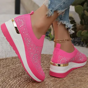 Dettaglio ravvicinato delle sneakers con zeppa in maglia rosa e strass brillanti.