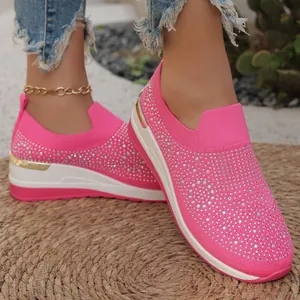 Primo piano di sneakers rosa con zeppa in maglia e dettagli in strass per donna