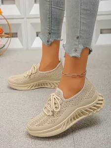 Détail de baskets de course en maille beige respirante avec une semelle texturée