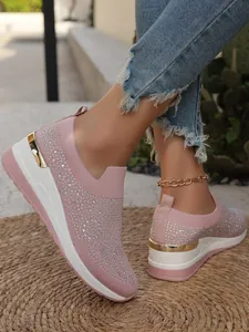 Primo piano di sneaker con zeppa in maglia rosa con dettagli in strass scintillanti da donna