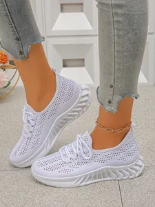 Gros plan sur des baskets blanches en maille respirante pour femmes à semelles épaisses