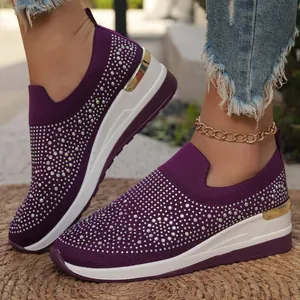 Dettaglio ravvicinato di sneaker a zeppa in maglia viola con strass per donna.