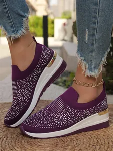 Dettaglio scarpe sneaker con zeppa in maglia viola per donna e strass scintillanti