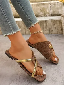 Detailansicht der braunen Stoff-Flachsandalen für Damen mit Fransen und Goldriemen