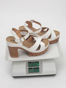 Detailed side view of white platform sandals on a digital scale showing weight of 0.36kg