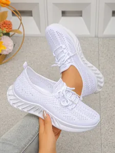 Détail montrant la tige en maille blanche respirante et la semelle des chaussures de course.