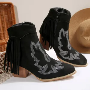 Detailed view of black Western boots with white embroidery and side fringe tassels