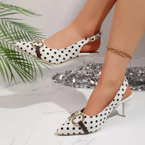 Zapatos slingback de lunares blancos con hebilla dorada, mostrados en modelo
