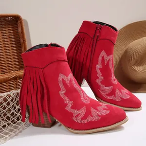 Detailed side view of red Western fringe ankle boots with white embroidery