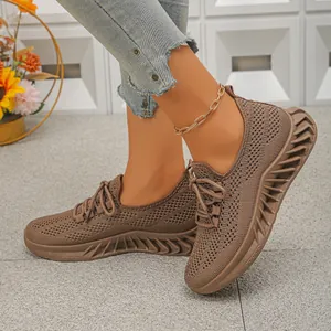 Gros plan de baskets de sport en maille respirante marron avec une semelle ondulée très tendance
