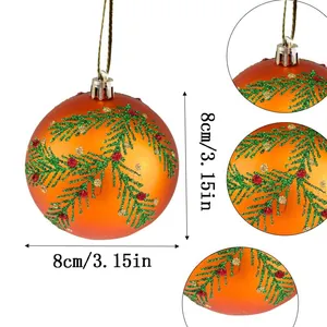 Dettaglio pallina di Natale arancione 8cm con motivo a rami di pino glitterati