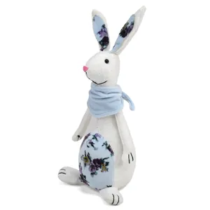 Close-up detail of white fabric Easter bunny with floral patterns and a light blue scarf