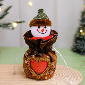 Gros plan d'un sac cadeau de Noël bonhomme de neige avec tête en peluche et cœur rouge
