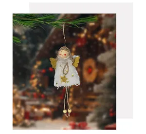 Detail view of a white plush angel girl ornament with golden wings hanging on a tree.