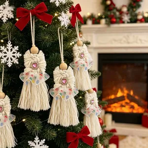 Détail des ornements d'anges en macramé blanc faits à la main sur un sapin de Noël
