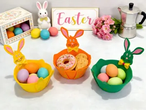 Drei farbenfrohe Osterkörbe aus Filz in Hasenform, dekoriert mit Eiern und Keksen im Set