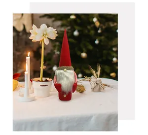 Detailed shot of a red felt Christmas gnome wine bottle cover on a festive table