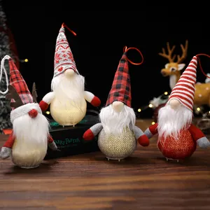 4er-Set leuchtende Plüsch-Weihnachtswichtel-Ornamente mit festlichen Hüten auf Holztisch