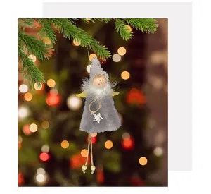 Detailansicht von flauschigem Engelmädchen-Anhänger an einem warmen Weihnachtsbaum