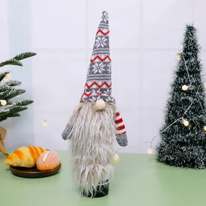 Handgebreide kerstkabouter wijnfleshoes voor een feestelijke tafeldecoratie