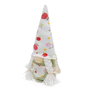 Detail of a fruit-themed Christmas gnome doll with white braids and cherry apron