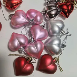 Vista dettagliata di 12 ornamenti a forma di cuore galvanizzati in rosa, rosso e argento