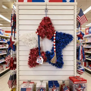 Red white and blue tinsel star wreath for Independence Day celebration hanging on display.