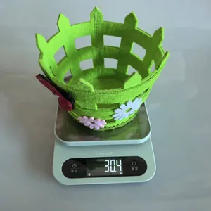 Green non-woven Easter fence basket showing a lightweight measurement of 30.4g on a scale.