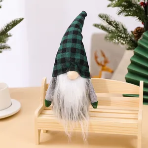 Kerstkabouter met groen geruite muts zittend op een miniatuur houten bankje decoratie