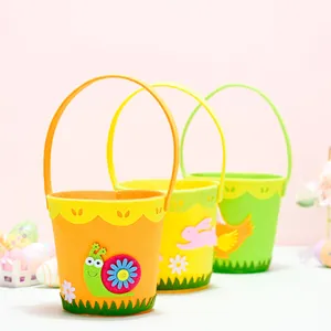 Tre cestini pasquali in feltro colorato con decorazioni animali su sfondo rosa