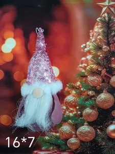 Close-up of a pink sequined Christmas gnome ornament hanging by a glowing festive tree.