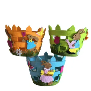 Colorful Easter felt baskets with bunny and garden decorations on white background