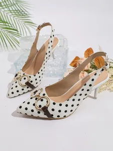 Vista detallada de elegantes zapatos slingback de lunares blancos con hebilla dorada
