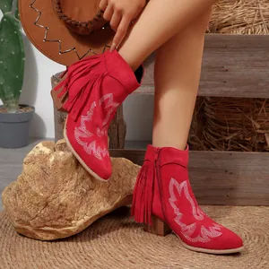 Detailed view of red Western fringe ankle boots with embroidery and chunky heels.