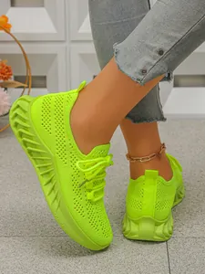 Détail des chaussures de course en maille vert fluo respirantes à semelles ondulées