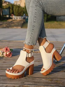 Close-up of white high heel platform sandals with peep-toe and buckle strap detail.