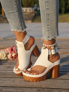 Detailed view of stylish white platform block heel sandals with buckle strap and toe loop.