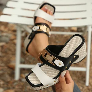 Detalle de sandalias de cuña para mujer con hebilla dorada y plantilla tejida
