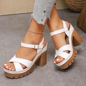 A detailed view of white high heel platform sandals featuring elegant cross straps