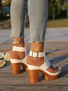 Detailed shot of white platform chunky heel sandals featuring ankle strap and toe loop