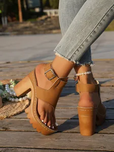 Detail of tan platform sandals with thick heels and buckle toe-loop design