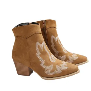 Brown suede western ankle boots featuring white embroidery, pointed toes, and chunky heels